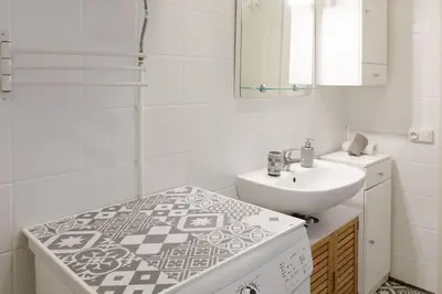 a white bathroom with a sink and a mirror at Jolie studio - Proche Promenade des anglais in Nice