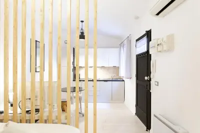 a room with a table and a hallway with a kitchen at Jolie studio - Proche Promenade des anglais in Nice