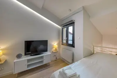 a white bedroom with a bed and a television at #14 Duplex Tonduti terrace 5min Old Town in Nice