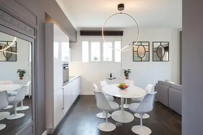 a kitchen and dining room with a white table and chairs at #24 Marie-Claire Suite Sea view/balcony/AC/5min port in Villefranche-sur-Mer