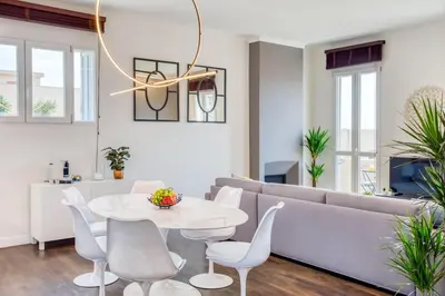 a living room with a couch and a table and chairs at #24 Marie-Claire Suite Sea view/balcony/AC/5min port in Villefranche-sur-Mer