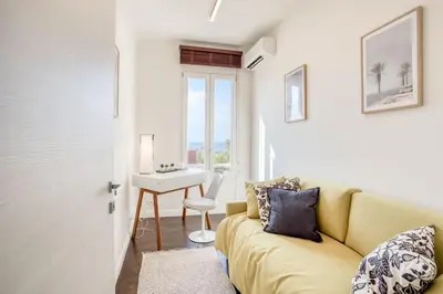 a living room with a couch and a table and a desk at #24 Marie-Claire Suite Sea view/balcony/AC/5min port in Villefranche-sur-Mer