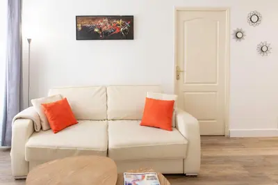 a living room with a white couch with orange pillows at #28 1 BDR Flat AC Balcony Hper Central 10mins to Beach & old town in Nice