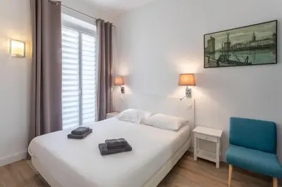 a bedroom with a white bed and a blue chair at #28 1 BDR Flat AC Balcony Hper Central 10mins to Beach & old town in Nice