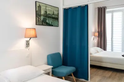 a bedroom with a blue chair and a bed at #28 1 BDR Flat AC Balcony Hper Central 10mins to Beach & old town in Nice