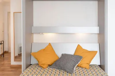 a bed with two pillows on top of it at #1 Studio Fontaine de la Ville-WIFI in Nice
