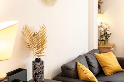 a living room with a couch and a vase with a plant at #1 Studio Fontaine de la Ville-WIFI in Nice