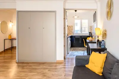 a living room with a gray couch and a kitchen at #1 Studio Fontaine de la Ville-WIFI in Nice