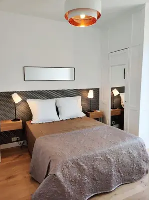 a bedroom with a large bed with two pillows at Top floor nest, balcony close to sea and old-town Bail Mobilité in Nice