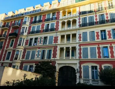 a large red and white building with balconies at Top floor nest, balcony close to sea and old-town Bail Mobilité in Nice