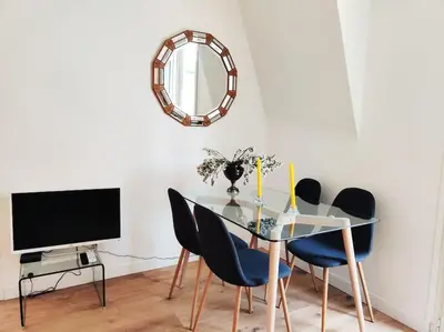 a dining room with a glass table and chairs at Top floor nest, balcony close to sea and old-town Bail Mobilité in Nice
