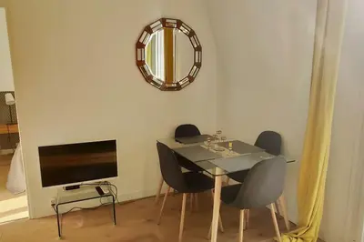 a dining room with a table and chairs and a mirror at Top floor nest, balcony close to sea and old-town Bail Mobilité in Nice