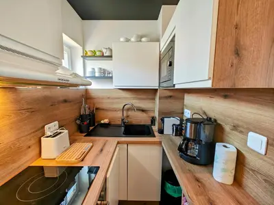 a small kitchen with white cabinets and a sink at Cozy roof terrace near Promenade des Anglais - AC in Nice
