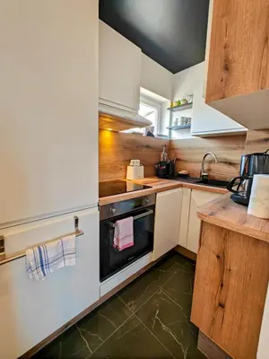 a kitchen with white cabinets and a black oven at Cozy roof terrace near Promenade des Anglais - AC in Nice