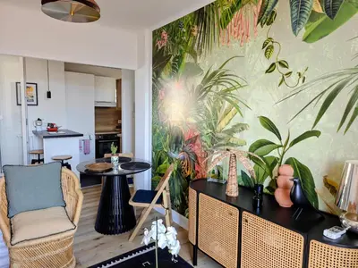 a living room with a tropical mural on the wall at Cozy roof terrace near Promenade des Anglais - AC in Nice