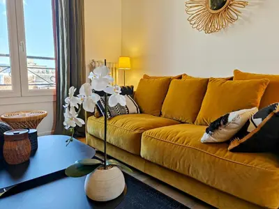 a living room with a yellow couch and a table at Cozy roof terrace near Promenade des Anglais - AC in Nice