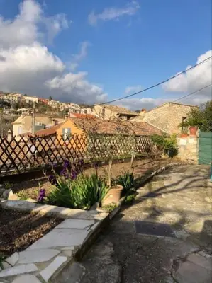 a street with a fence and some plants at Maison de village vue montagne in La Gaude