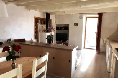 a kitchen and dining room with a table and a counter at Maison de village vue montagne in La Gaude