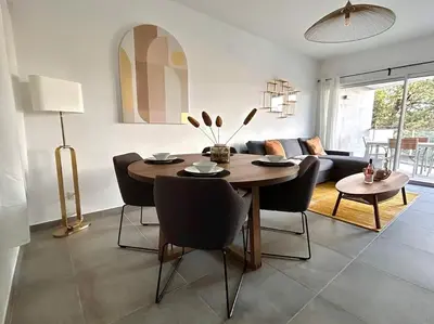 a living room with a table and chairs and a couch at Blue Pearl 102 By Avecoeur in Nice