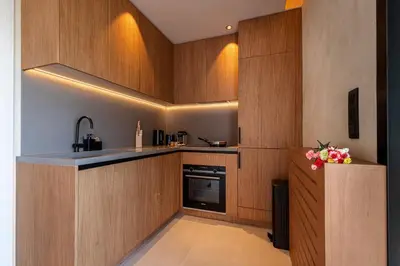 a kitchen with wooden cabinets and a counter with flowers at FEEL HOME - SAFRANETTE in Villefranche-sur-Mer