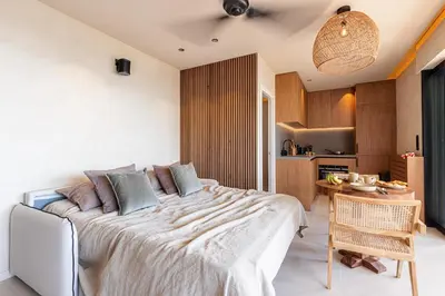 a bedroom with a large bed and a kitchen at FEEL HOME - SAFRANETTE in Villefranche-sur-Mer