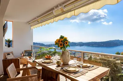 a dining room with a table with a view of the ocean at FEEL HOME - SAFRANETTE in Villefranche-sur-Mer