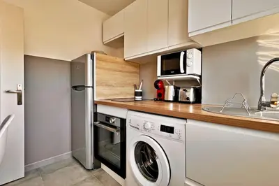 a kitchen with a washing machine and a microwave at L'Azur Plaisance in Nice
