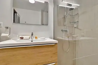 a bathroom with a sink and a shower with a mirror at L'Azur Plaisance in Nice