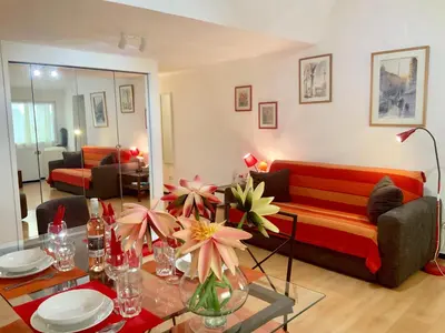 a living room with a red couch and a table at Very cosy flat in heart of Old Town of Nice near beach in Nice