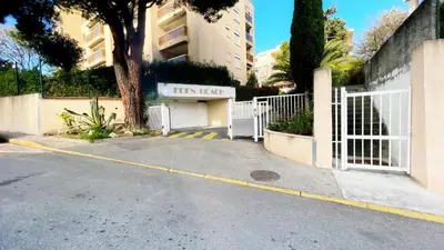 a parking lot with a white gate and a building at Eden Beach in Cagnes-sur-Mer