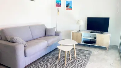 a living room with a couch and a tv at La Couronne du Cros in Cagnes-sur-Mer