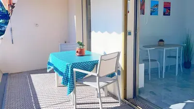 a table with a blue table cloth and a table and chairs at La Couronne du Cros in Cagnes-sur-Mer