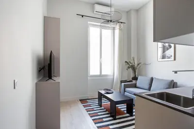 a kitchen and living room with a couch and a sink at Studio Francilia - Welkeys in Nice