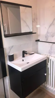 a bathroom with a black and white sink and a mirror at Renovated Apartment Near the Beach in Nice