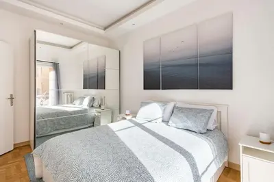 a bedroom with two beds and a mirror at Renovated Apartment Near the Beach in Nice