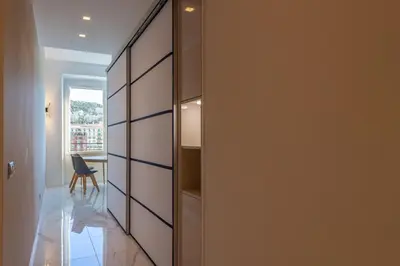 a room with a closet with a chair and a window at Sea view, vue sur la mer Port De Nice - Appartement de charme 2 P in Nice