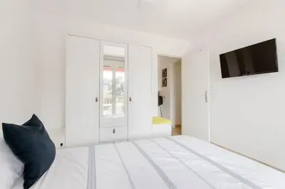 a white bedroom with a tv and a bed at Private room in renovated apartment - Tram 1 min walk in Nice