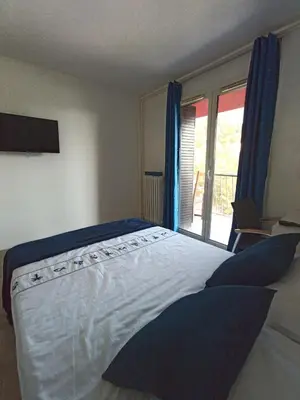 a bedroom with a large bed with a window at Private room in renovated apartment - Tram 1 min walk in Nice