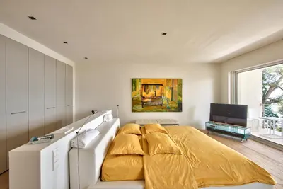 a bedroom with a large bed with a yellow bedspread at Villa Mont Boron, vue mer exceptionnelle in Nice