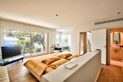 a bedroom with a large bed and a large window at Villa Mont Boron, vue mer exceptionnelle in Nice