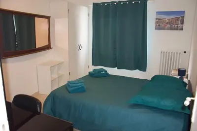 a bedroom with a blue bed and a window at 4 pièces à Nice - 20 min de la plage in Nice