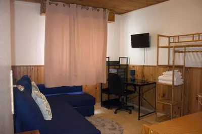 a living room with a blue couch and a desk at 4 pièces à Nice - 20 min de la plage in Nice