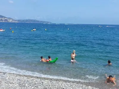 a group of people in the water at the beach at Nice & Les Cypres in Nice