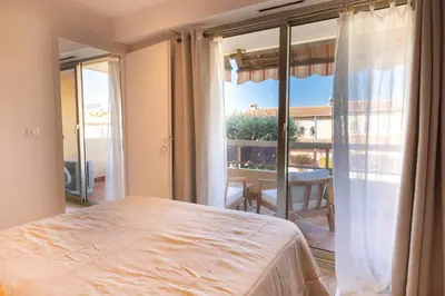 a bedroom with a bed and a large window at Lumineux, tout confort, Wifi & Terrace & Parking in Saint-Laurent-du-Var