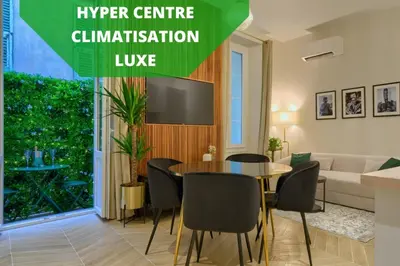 a living room with a table and chairs and a tv at CASA ALMA. Hyper Centre. Luxe. in Nice