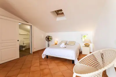 a white bedroom with a bed and two chairs at VILLA LUNA VI4339 By Riviera Holiday Homes in Èze