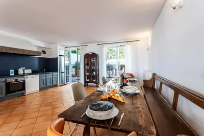 a kitchen and living room with a wooden table at VILLA LUNA VI4339 By Riviera Holiday Homes in Èze