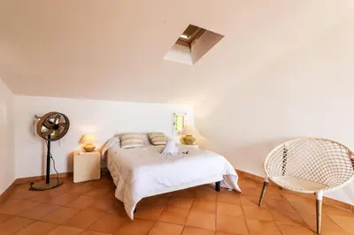 a bedroom with a bed and a fan and a chair at VILLA LUNA VI4339 By Riviera Holiday Homes in Èze
