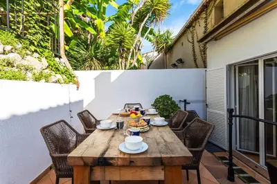 a wooden table on a patio with chairs at VILLA LUNA VI4339 By Riviera Holiday Homes in Èze