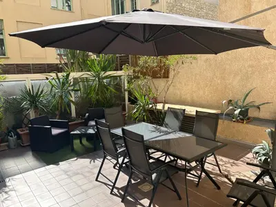 a table and chairs under an umbrella on a patio at Studio Centre Ville in Nice